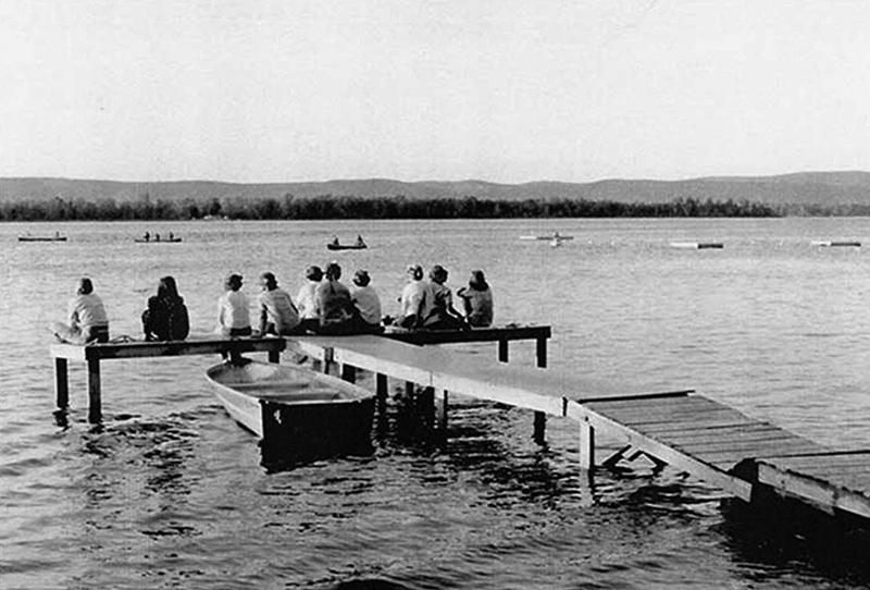 Black-and-white image of Girl Guide campers sitting on theOttawa riverfront dock at Camp Woolsey, 1940s (Courtesy Camp Woolsey Property Committee)