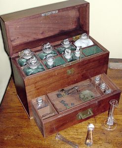 A colour photo of a travelling apothecary kit brought from England by Hamnett Pinhey in 1821. It is a mahogany case enclosing a mortar and pestle, graduated beaker, a set of scales for preparing medicines, and stoppered jars of blown glass (PPF Collection, Gift of the Estate of Ann Schneider))